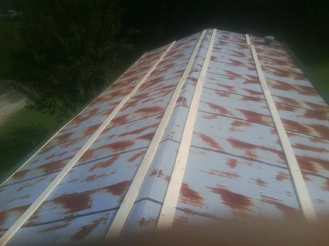 Rusted metal roof panels with new wood purlins before replacement — Storm Damage Roof Repair in Panama City by Roofing Brothers