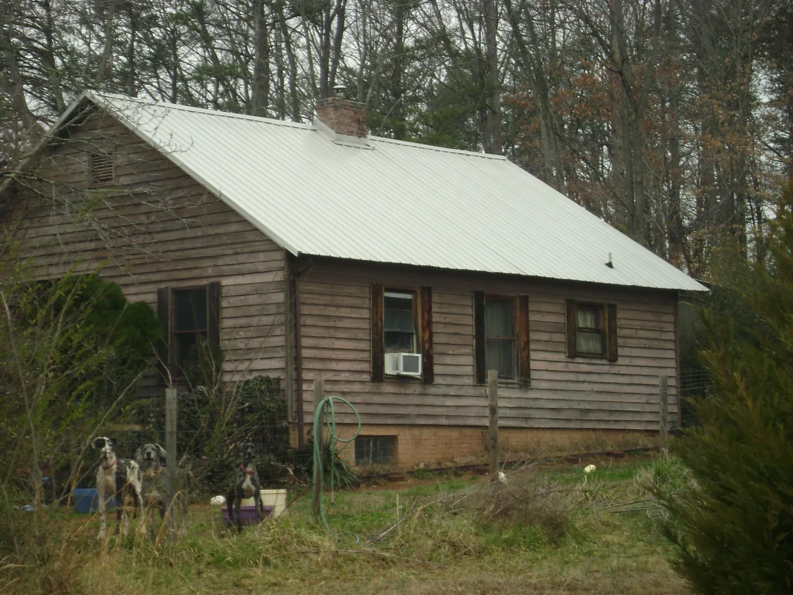 White metal roof on an old wood sided farmhouse, from a Asphalt Shingle Roof Repair job in Panama City
